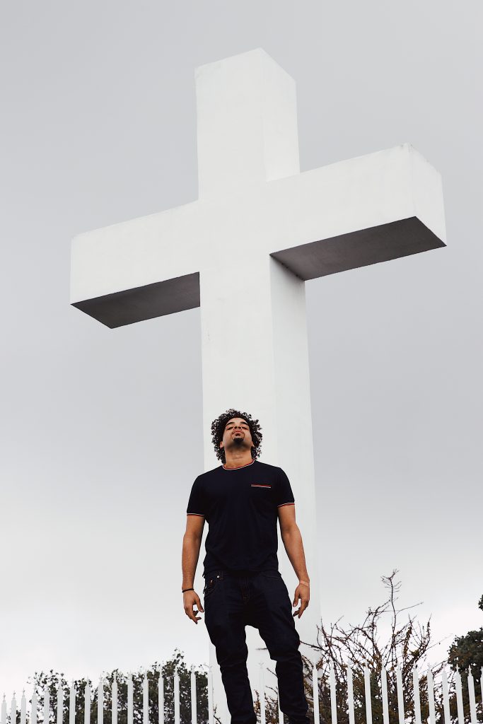 Man standing in front of giant white cross